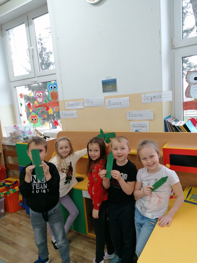 Trzy dziewczynki i dwoje chłopców tworzyło zielony zbiór kredek. 