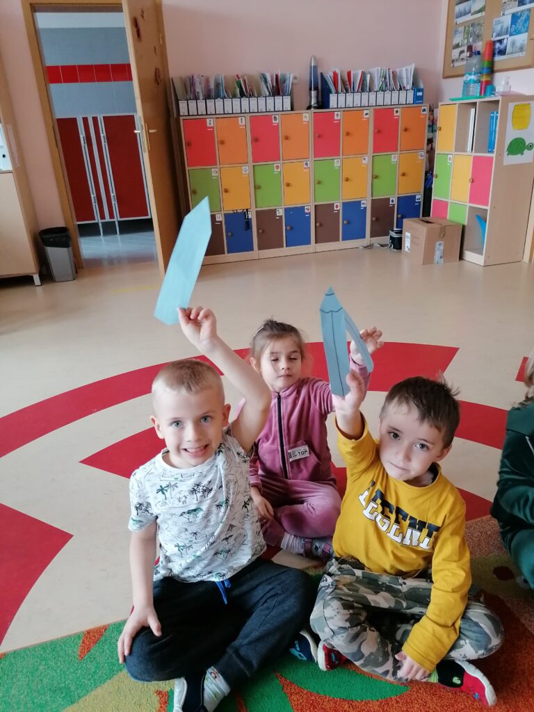 Jedna dziewczynka i dwóch chłopców tworzyło niebieski zbiór kredek. 