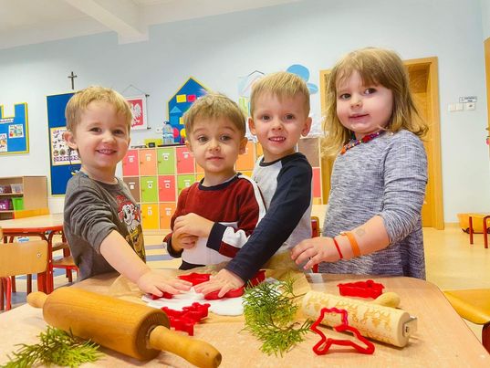  Dzieci wykrawają ozdoby choinkowe za pomocą świątecznych form